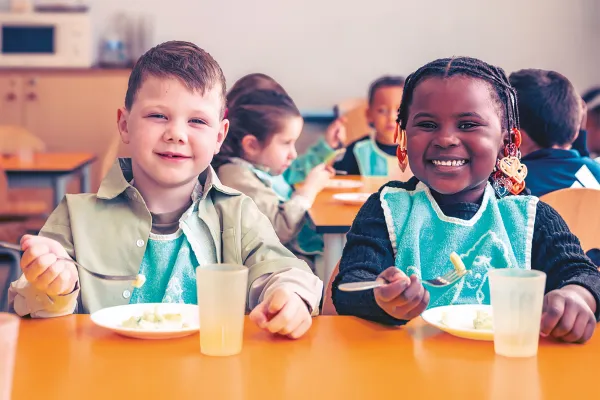 Des enfants mangent à la cantine